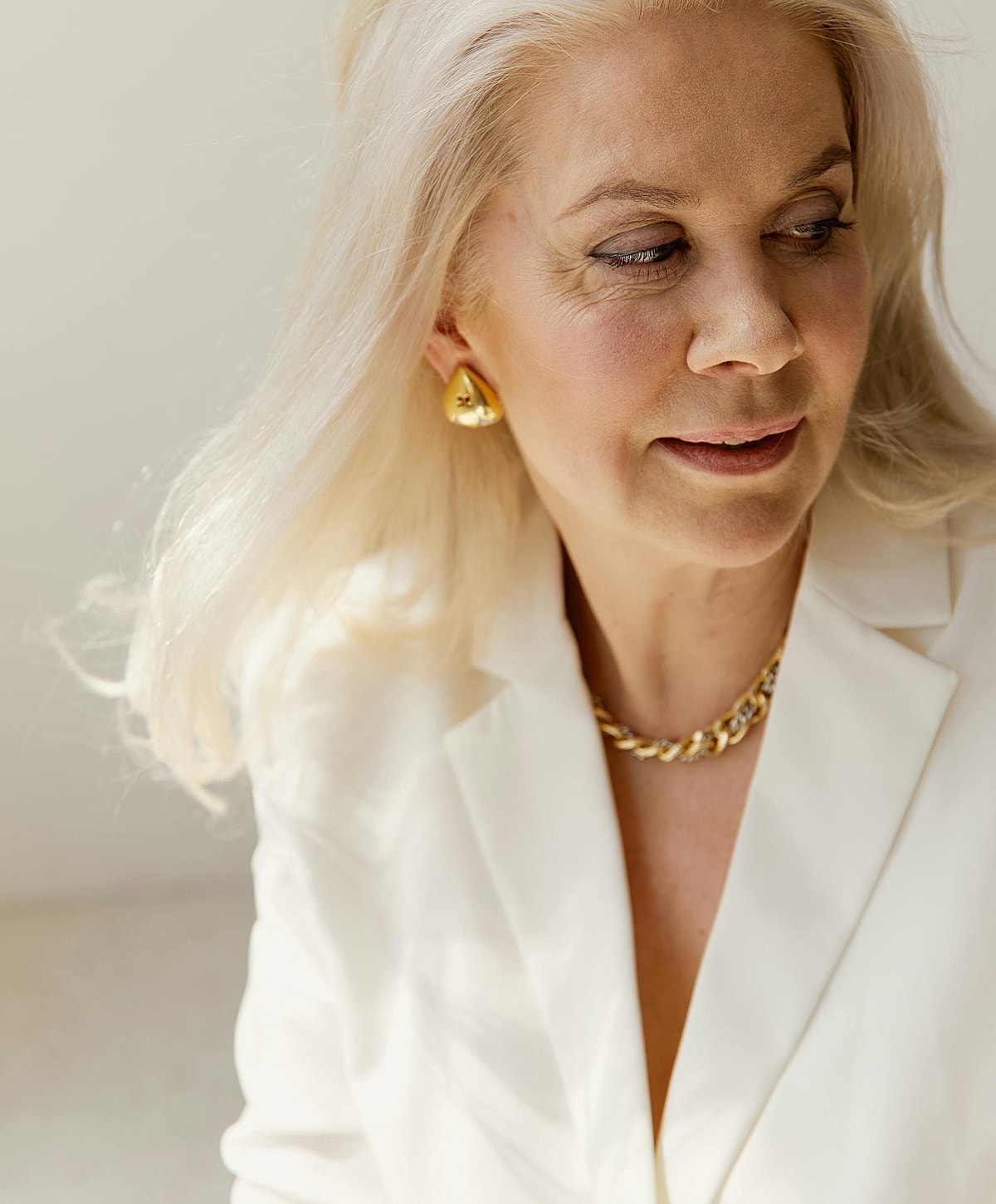 Woman with long blonde hair wearing elegant jewelry.