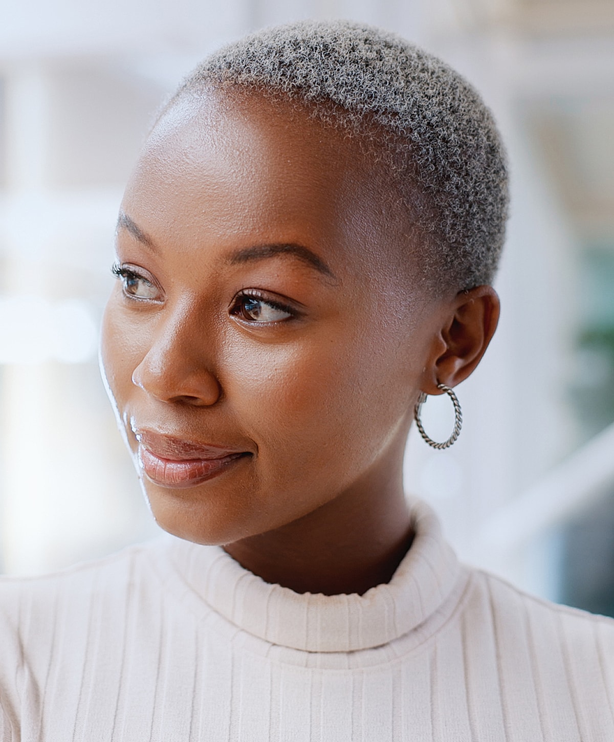 Woman with short gray hair and hoop earrings.