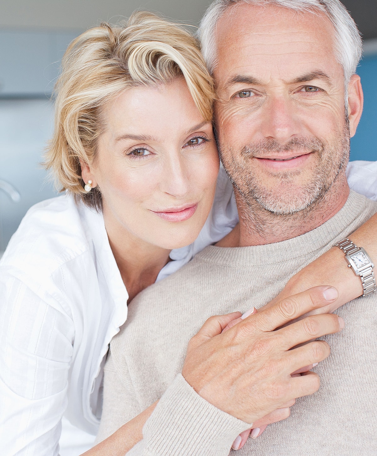 Smiling couple embracing in a cozy setting.