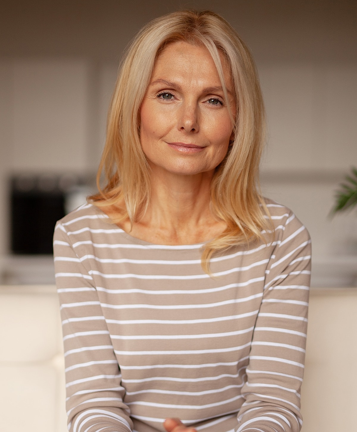 Middle-aged woman smiling softly at the camera.