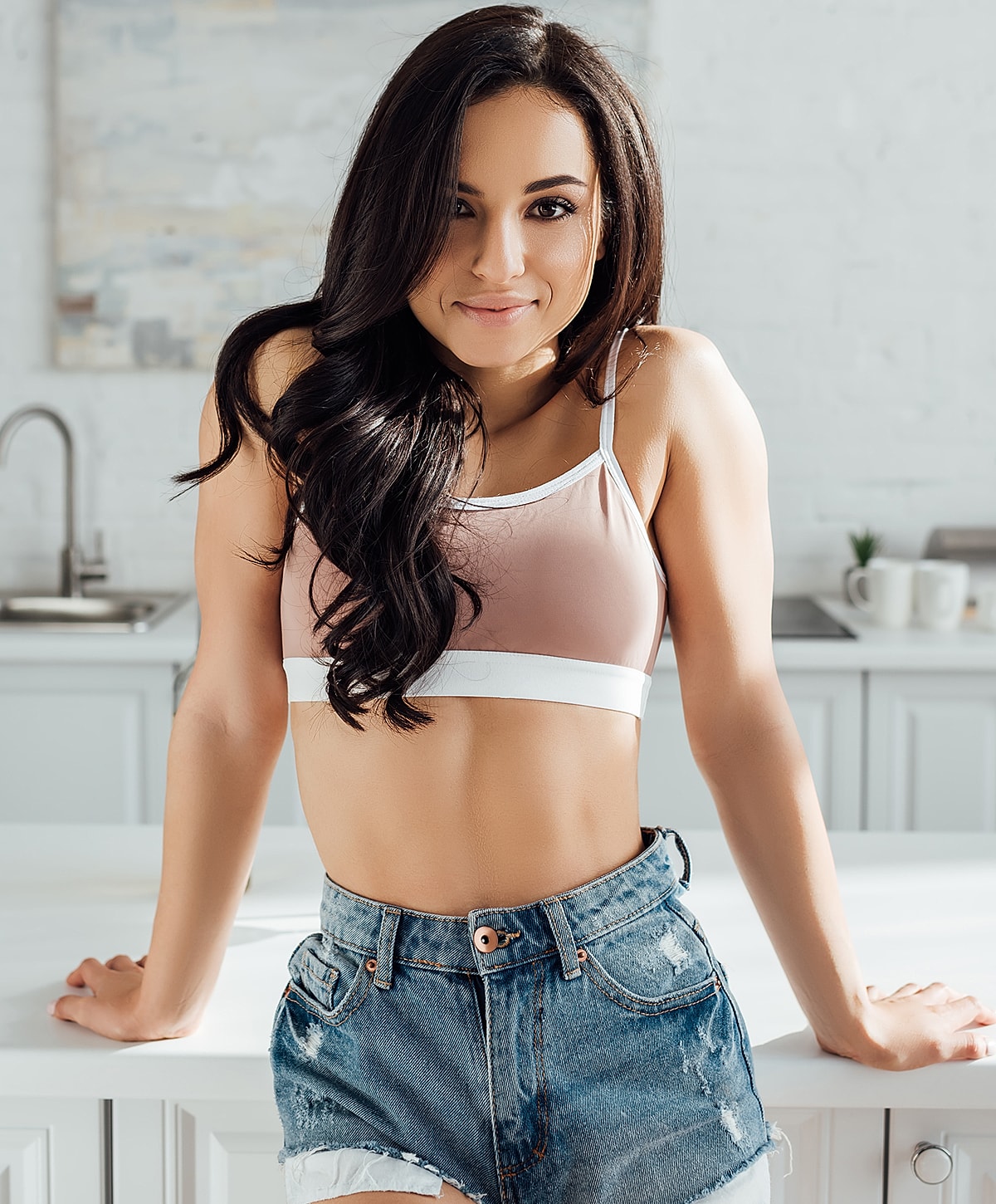 Woman in a casual kitchen outfit, smiling.