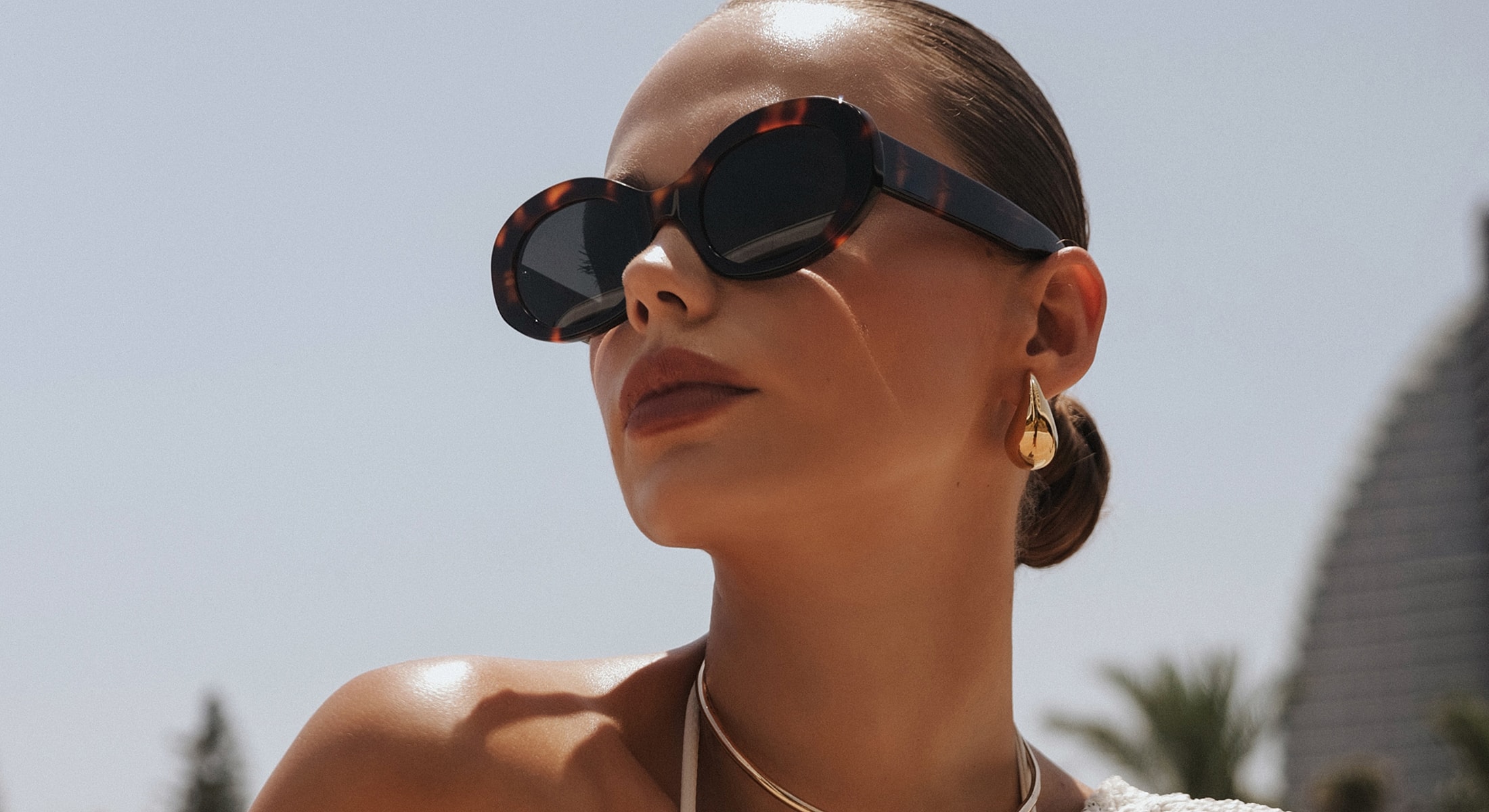 Woman wearing sunglasses and golden earrings.