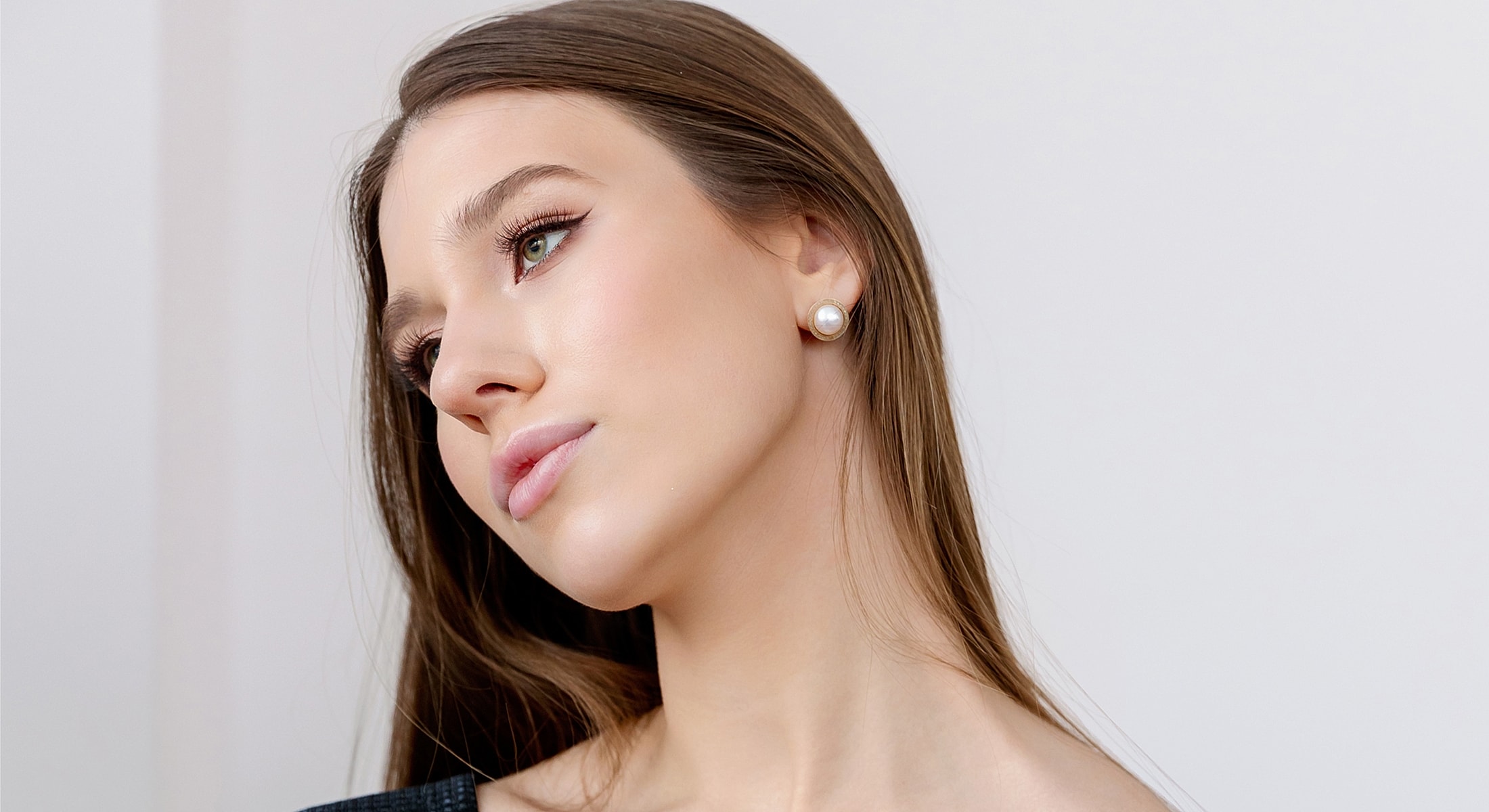 Woman with long hair and pearl earrings.